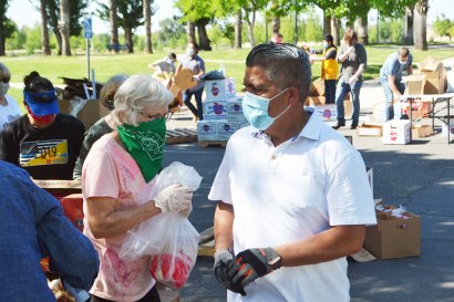 Juan Martinez (right) KCAO's Nutrition, Education and Hunger Prevention Director, orchestrated Friday's Heritage Park food distribution event.